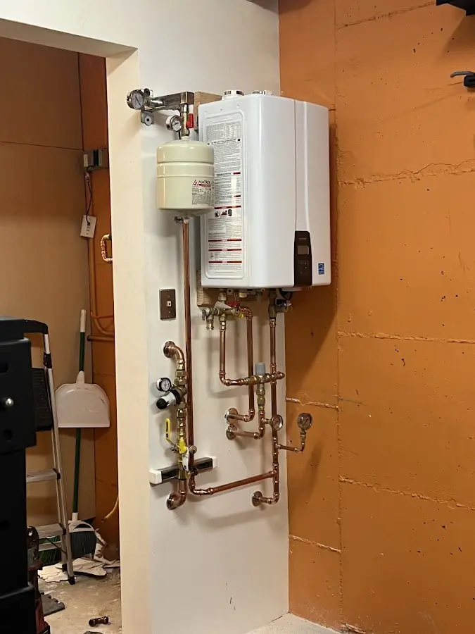 Plumbing technician inspecting water heater connections in Carroll
